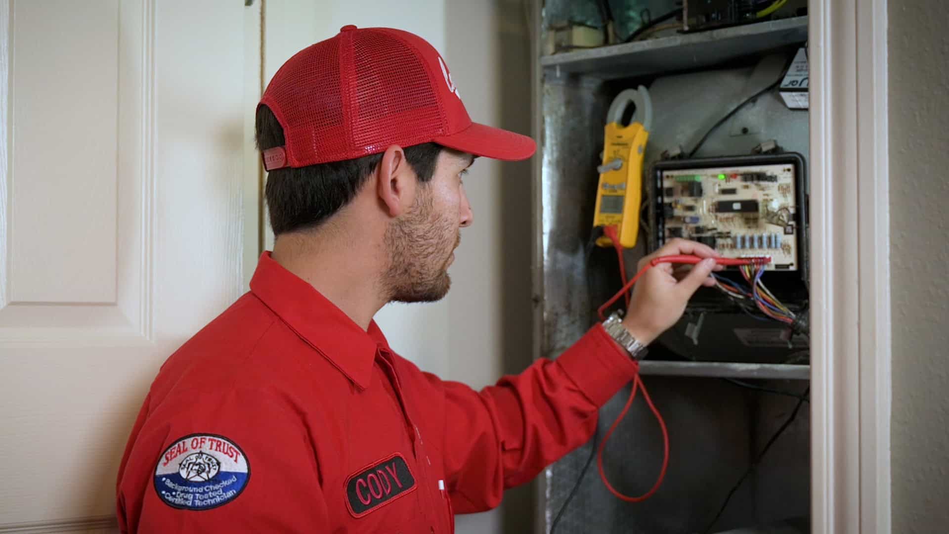 Cody testing a control board with a meter on a service call