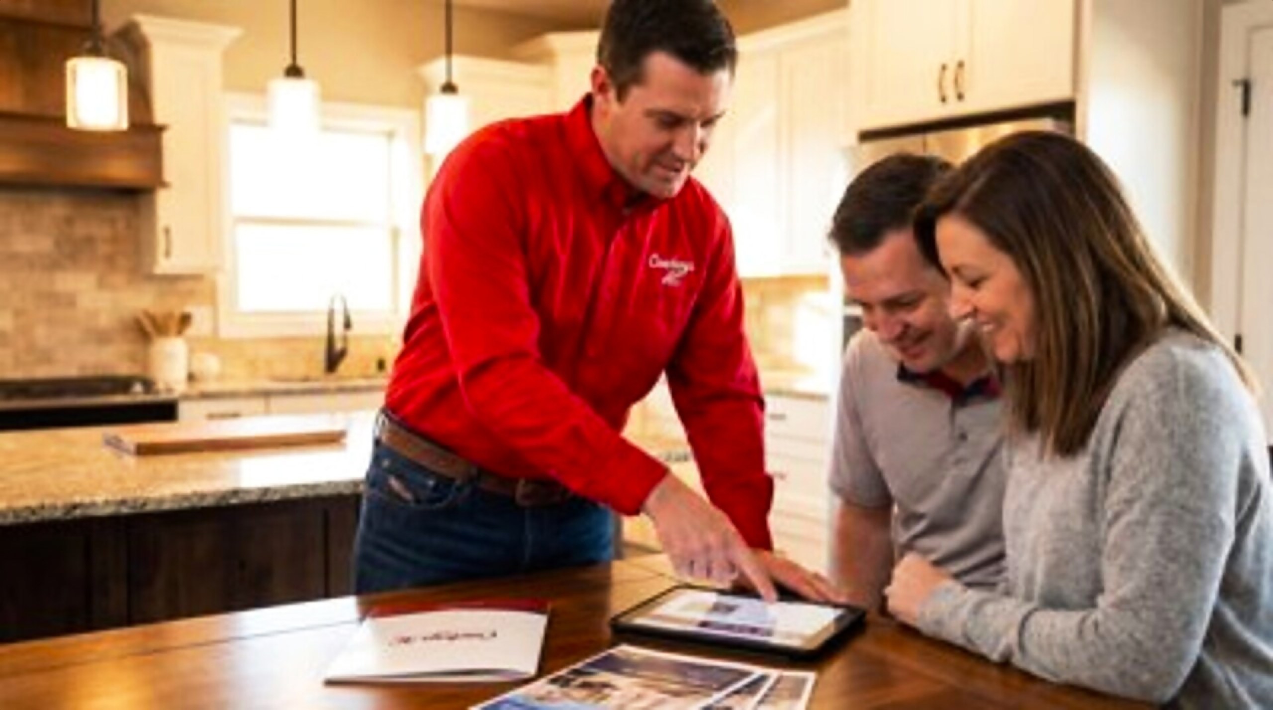 Technician showing options to homeowners at their kitchen table