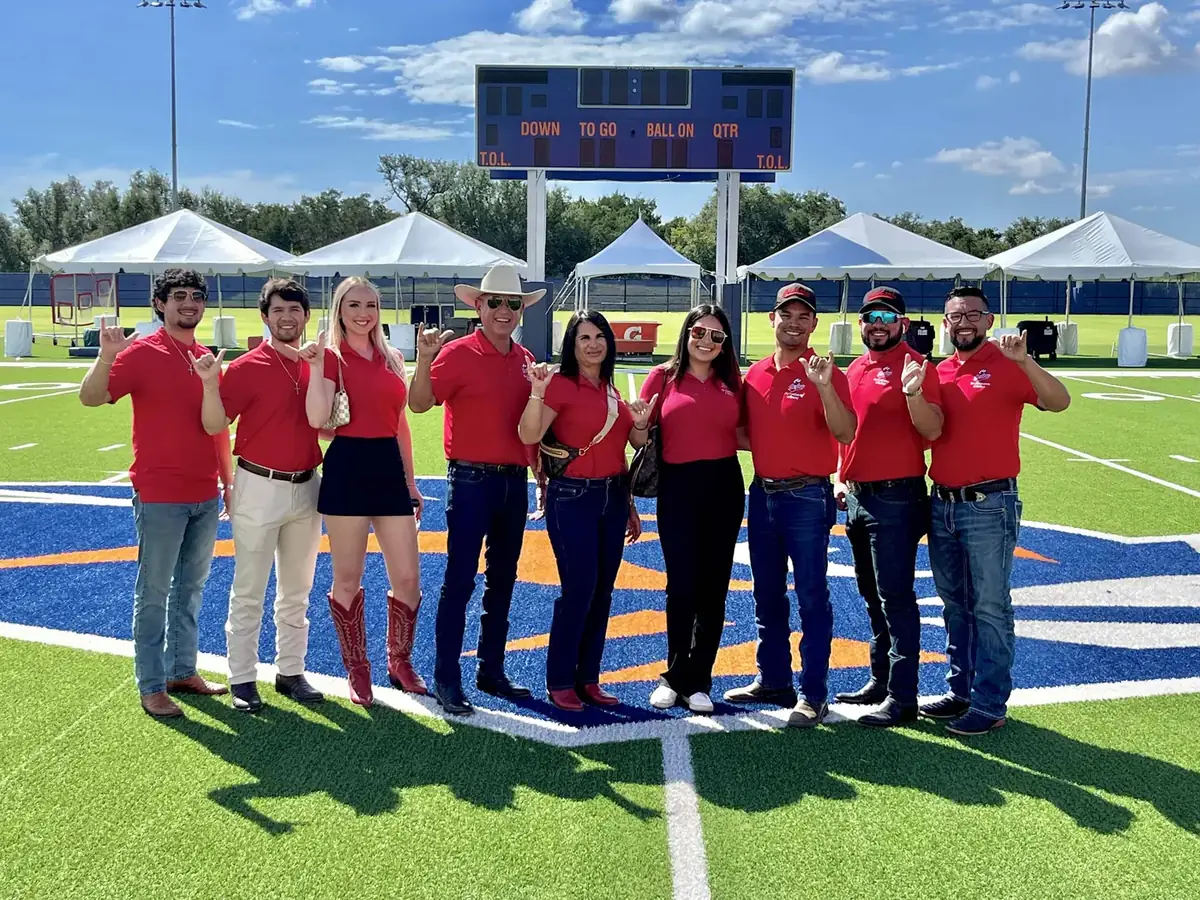 The Cowboy's crew in red shirts on the UTSA football field
